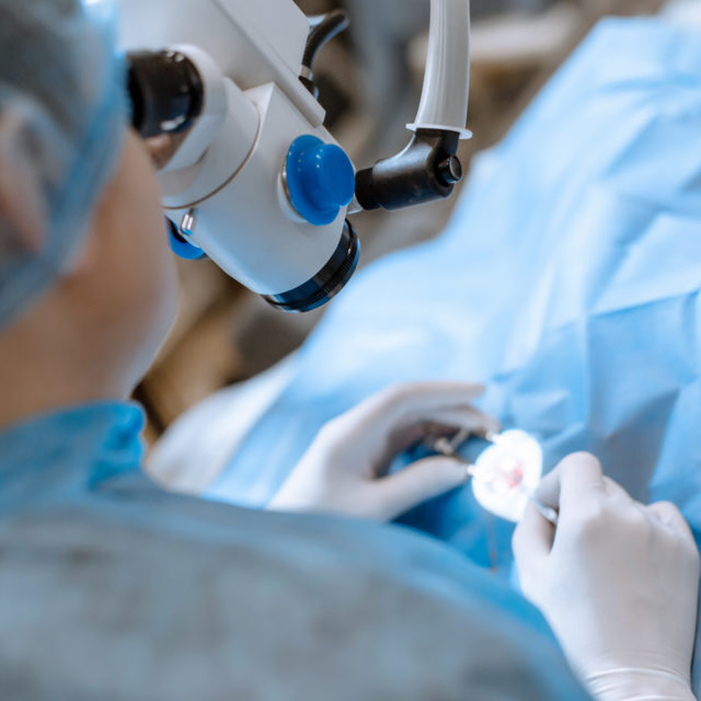 A professional ophthalmologist performs eye surgery with a microscope. The doctor inserted the dilator into the eye, washes and removes pus with a syringe. Endoscopic eye surgery. medical equipment.
